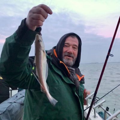 ankervissen Noordzee Man die vis omhoog houdt tijdens de zeevissen Noorzee trip