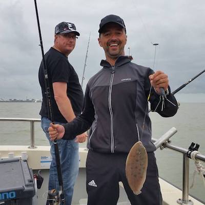 man met vissen welke gevangen zijn tijdens tongvissen westerschelde